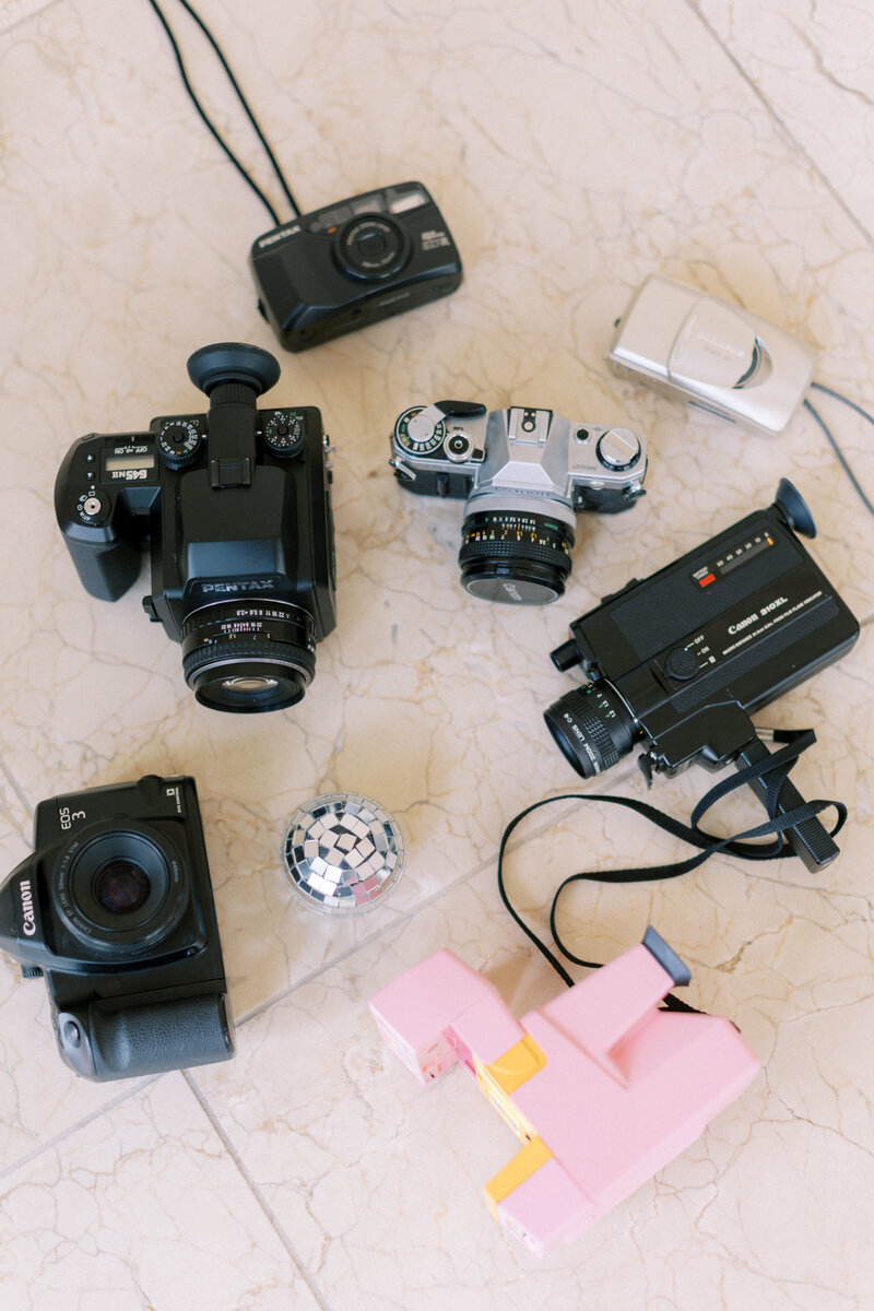 A variety of film cameras on a marble floor
