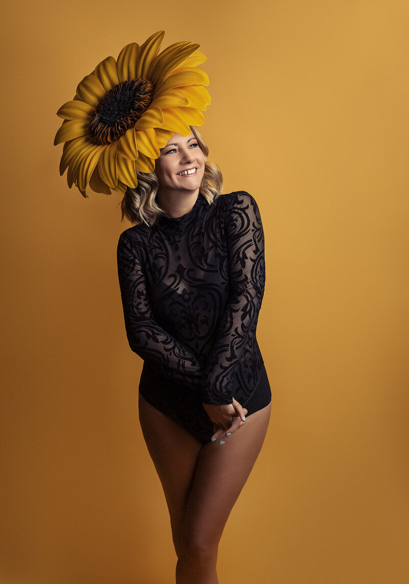 Woman in a brightly coloured fabric dress with it flying around in the frame. Taken in studio by Norwich Photographer Claire Howes.
