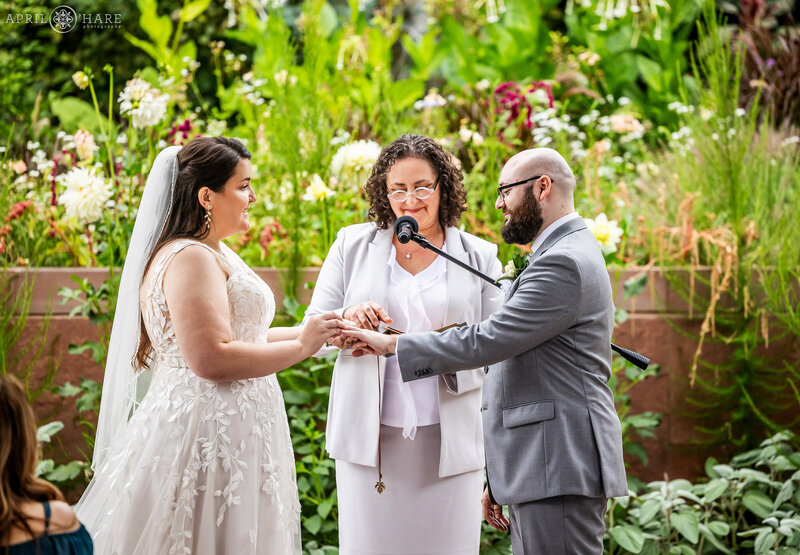Couple exhange rings in the Annuals Garden pavilion at their Denver Botanic Gardens wedding ceremony