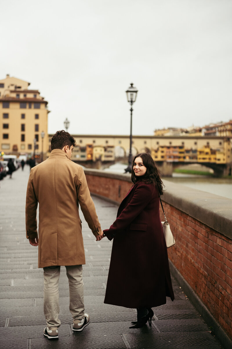 Same sex couple kiss under Rialto bridge in Venice as gondolas pass by after the proposal in Venice Italy