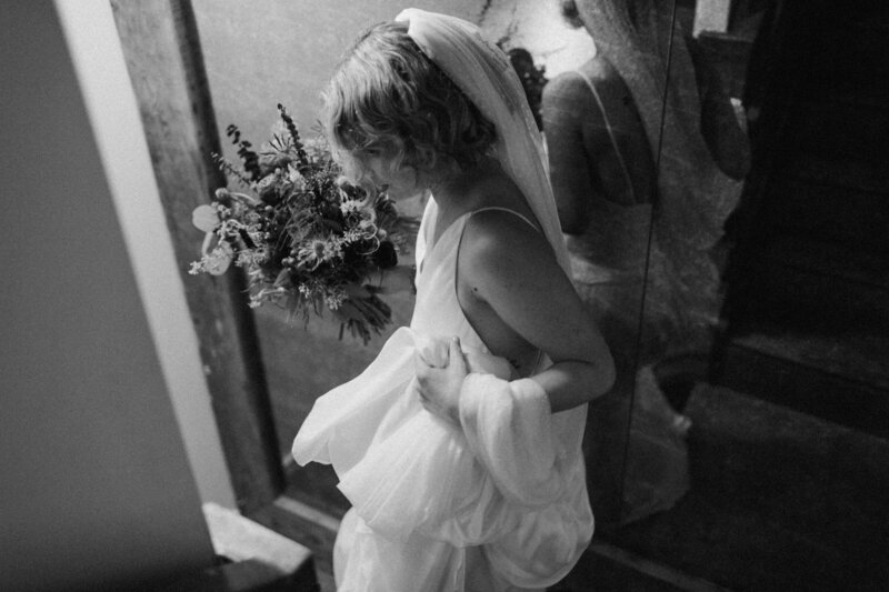 Bride holding dress in a New York City subway station.