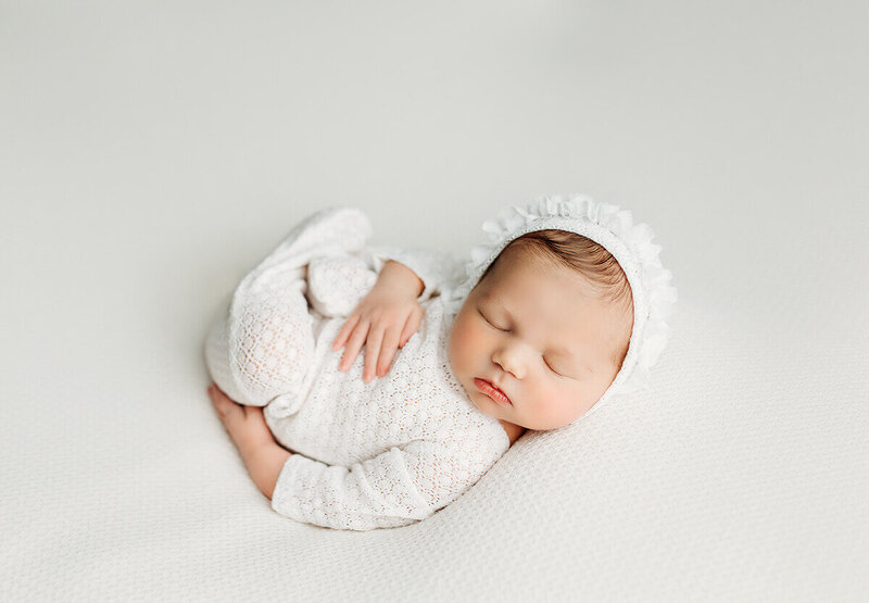 Timeless newborn portrait created with soft directional studio light, warm tones, and elegant fine-art styling.