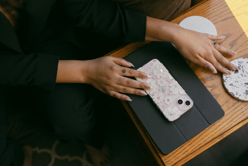 Catryce laying her hands on a tablet and phone on a table