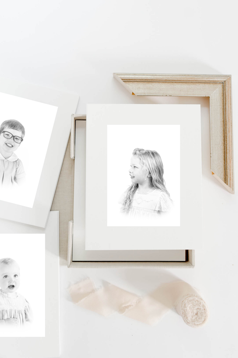A classic heirloom children's portrait featuring a young toddler with golden hair and bright blue eyes, dressed in a traditional light blue outfit. Timeless children's photography with a soft, painterly background.