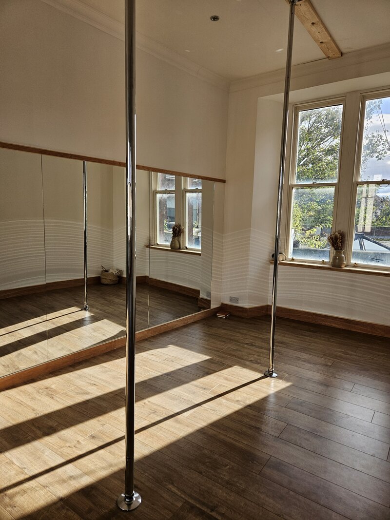 Pole studio with sunlight beaming in the window.