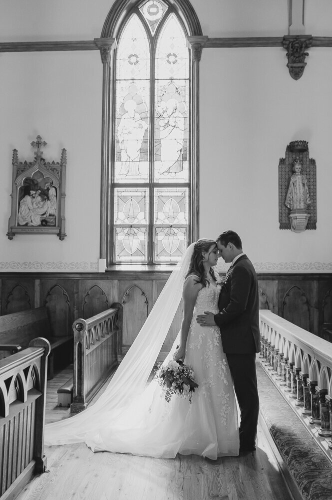 a bride and groom embracing in a church