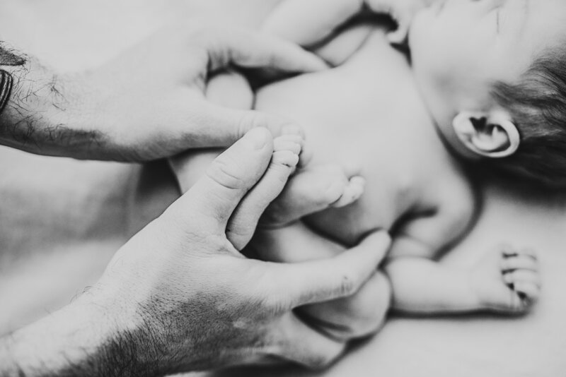 Perth newborn photography session - dad's hands against newborn soft skin - reflection