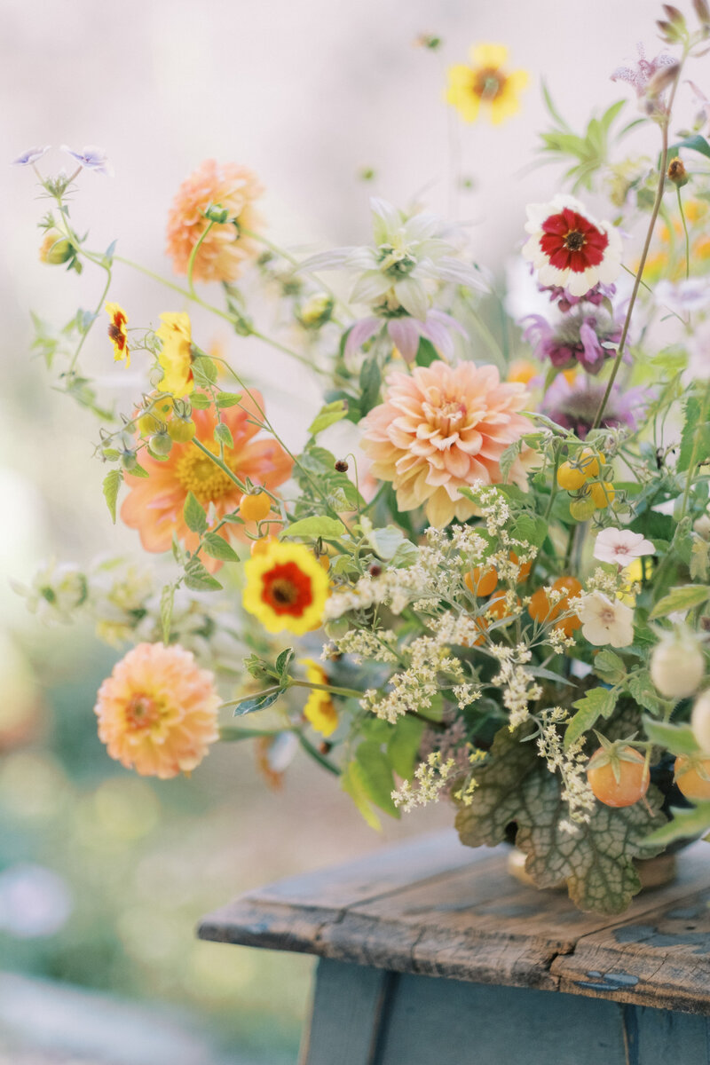 A single floral piece on a wooden chair.