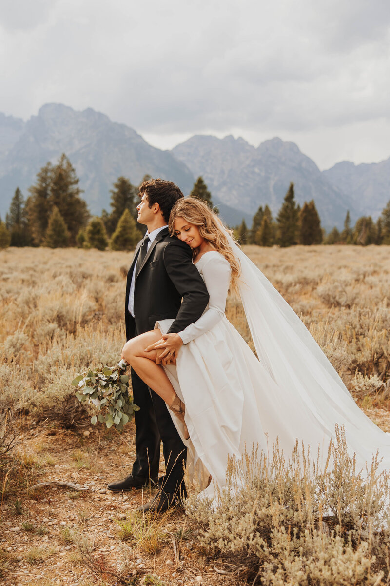bride and groom posing in field