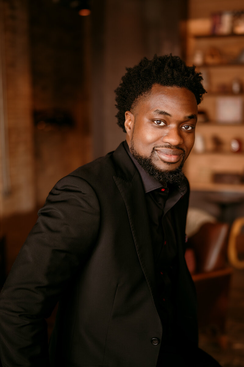 Professional online dating portrait of a confident man in a dark blazer, captured in a warm, inviting setting — Minneapolis online dating photographer.