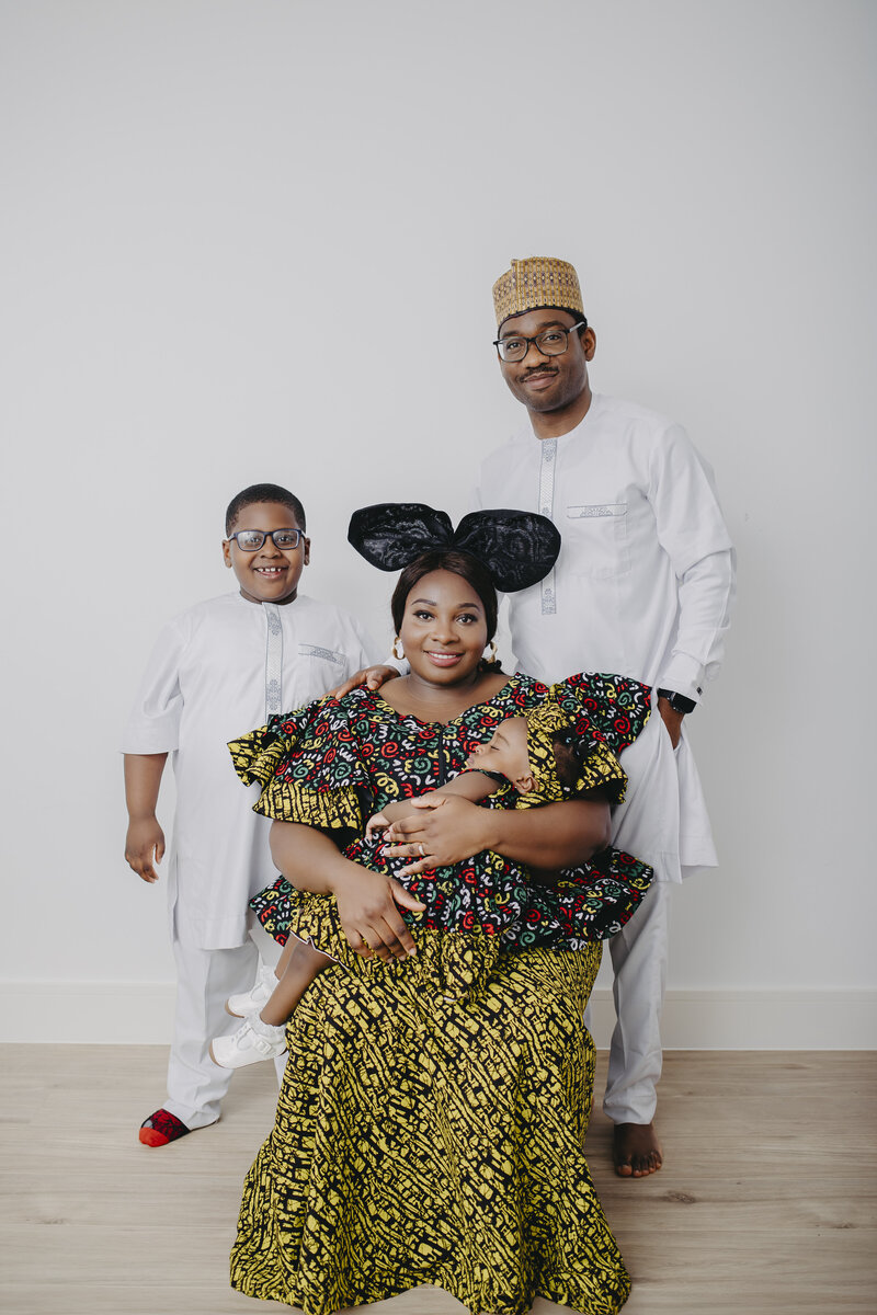 African family studio photoshoot with everyone dressed in vibrant traditional clothing, posing with warmth and pride, in Dublin