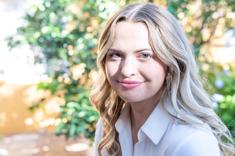 Smiling woman outdoors with greenery in the background, photographed by Vyrl Photo as part of Tucson brand photography.
