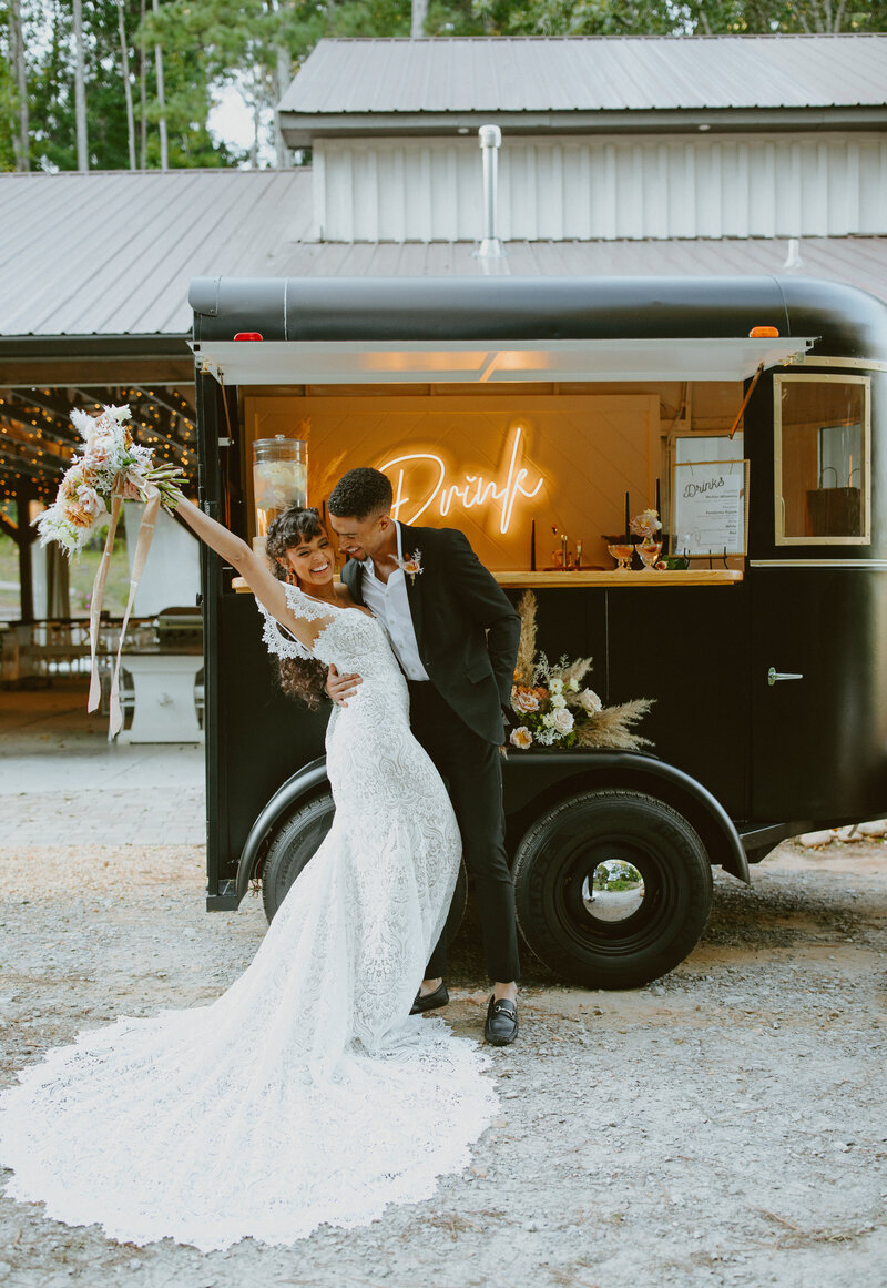 Newlyweds  posing in front of a food truck