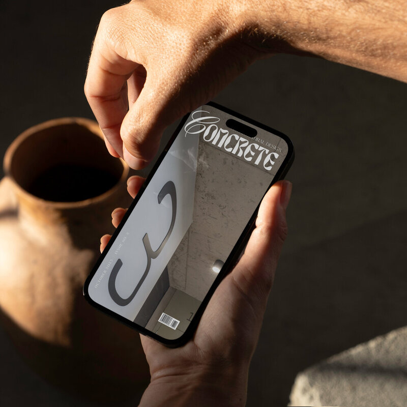 man holding a phone with a cover image of concrete design magazine