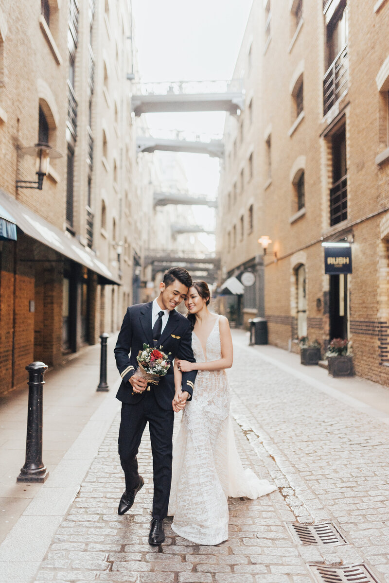 couple holding hands walking down street