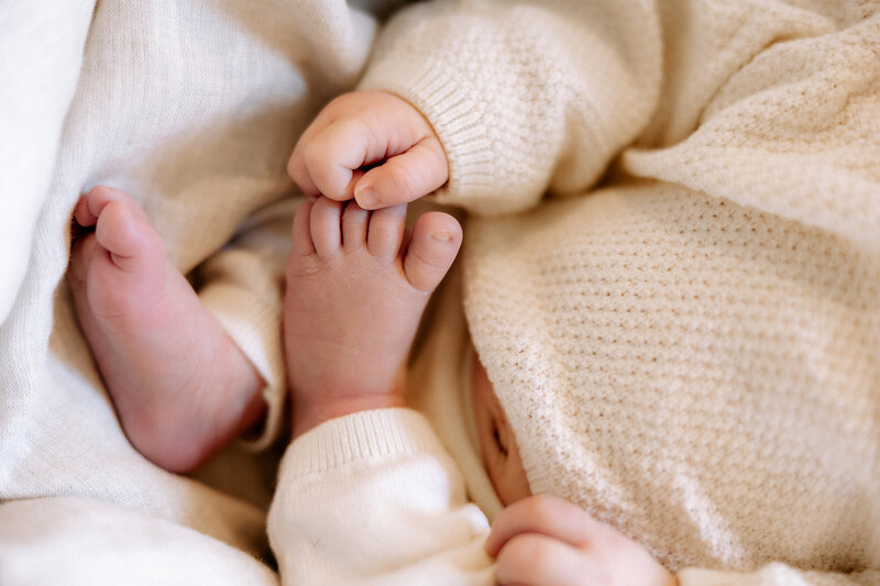 newborn holding her toes