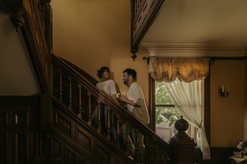 Engaged couple climbs steps of vintage Minnesota mansion