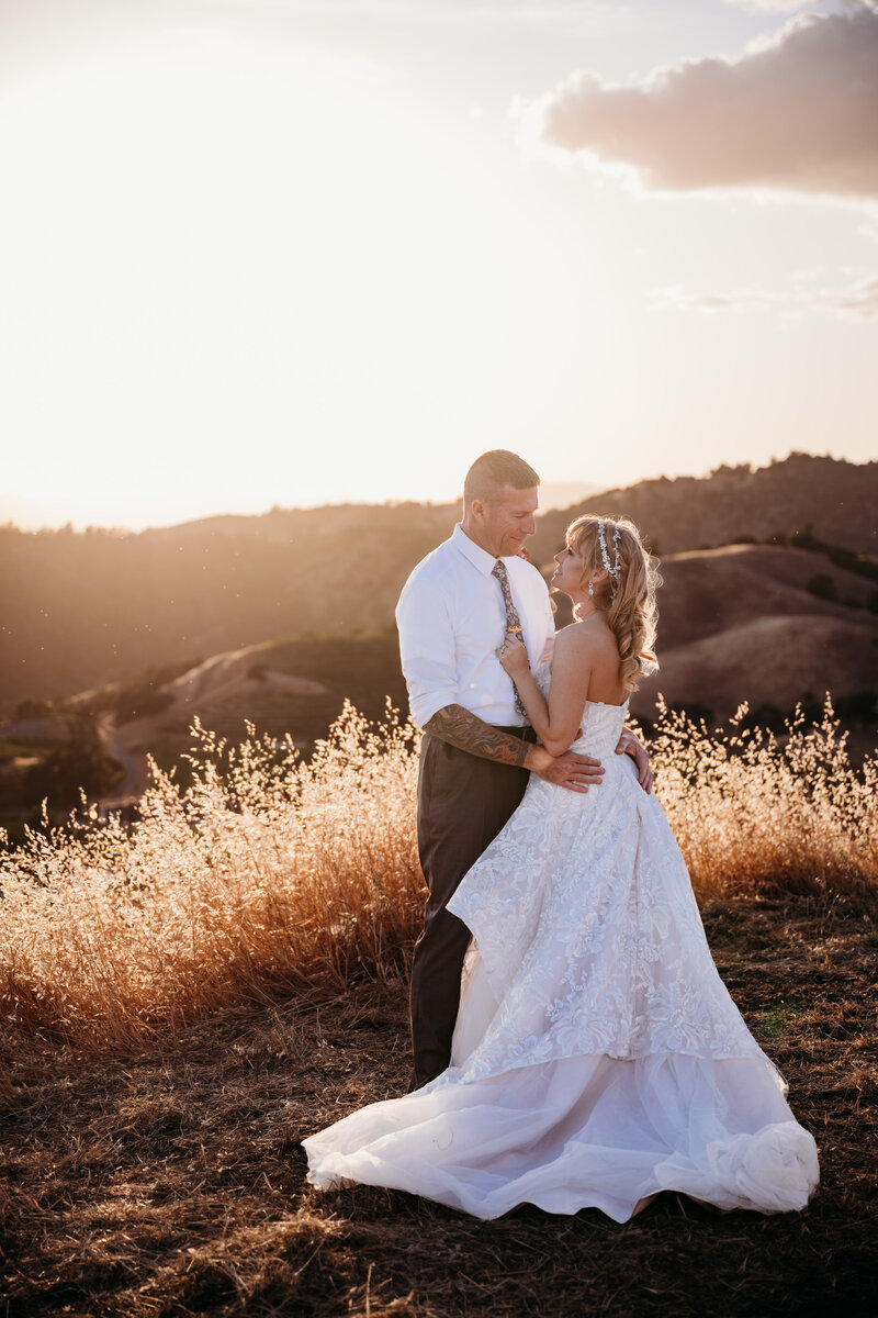 Bride and groom embracing each other during sunset