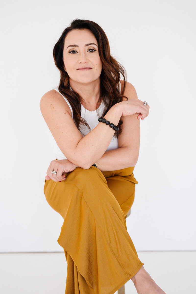 Danielle sitting professionally looking at the camera as she sits.