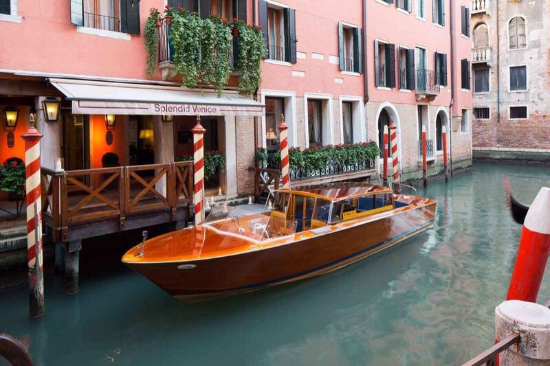 Luxury water taxi docked outside Hotel Splendid Venice, a boutique hotel with private canal access—featured on the Wish You WERE Here Italy Tour with author Christy Schillig.