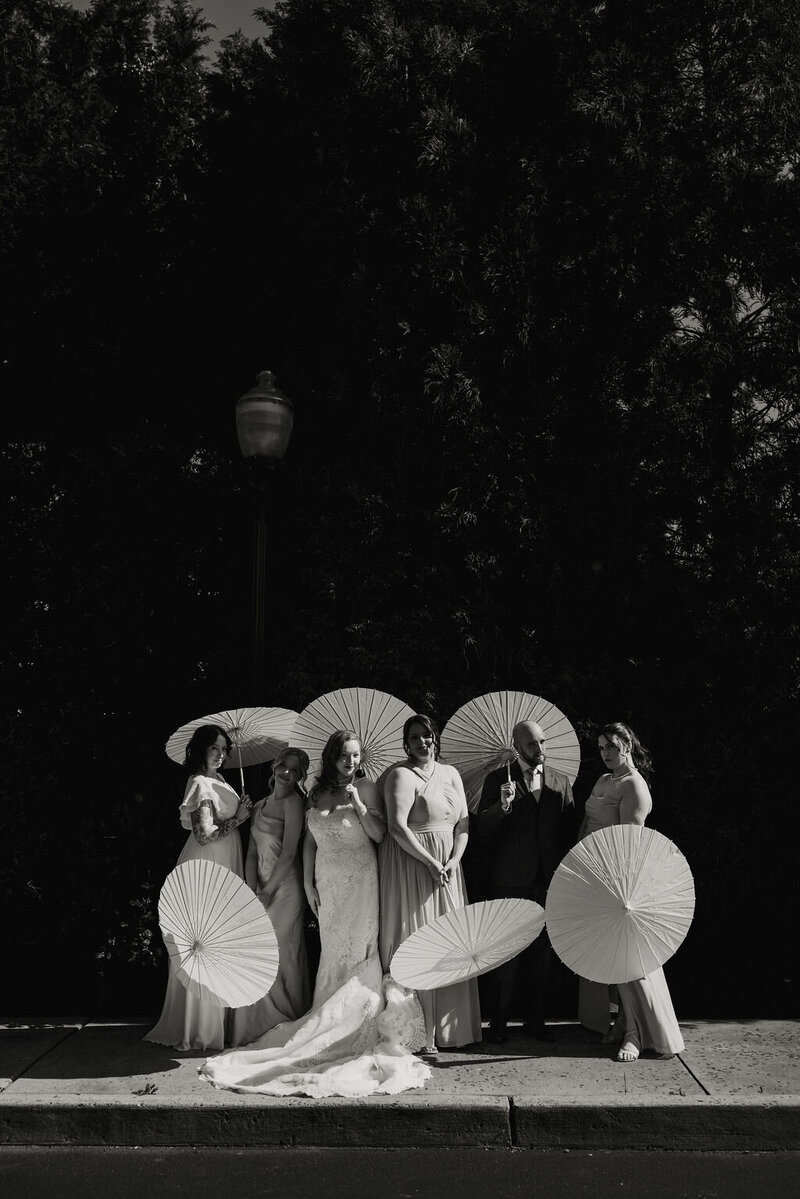 Bridal party celebrating with elegant parasol-style umbrellas during a wedding in New York City, captured by NYC wedding and elopement photographer Dom Augustine.
