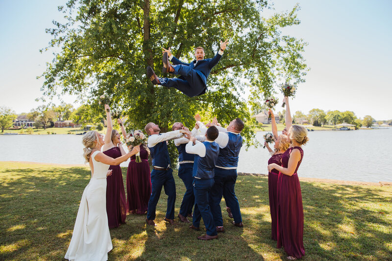 groom being thrown in the air during bridals