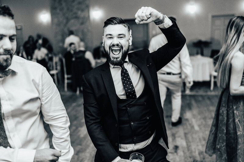 Male wedding guest fist pumps on the dancefloor at alternative  scottish wedding
