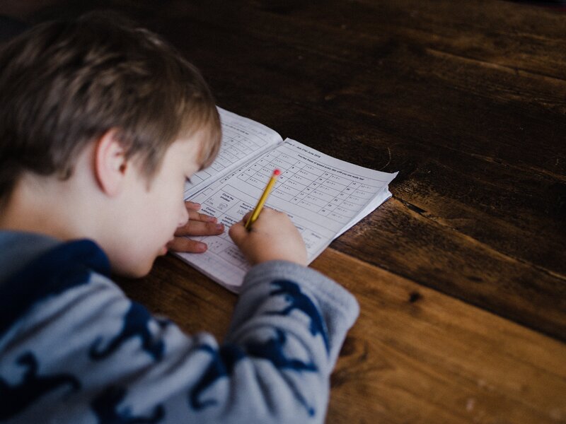 Young student taking a test using paper and pencil