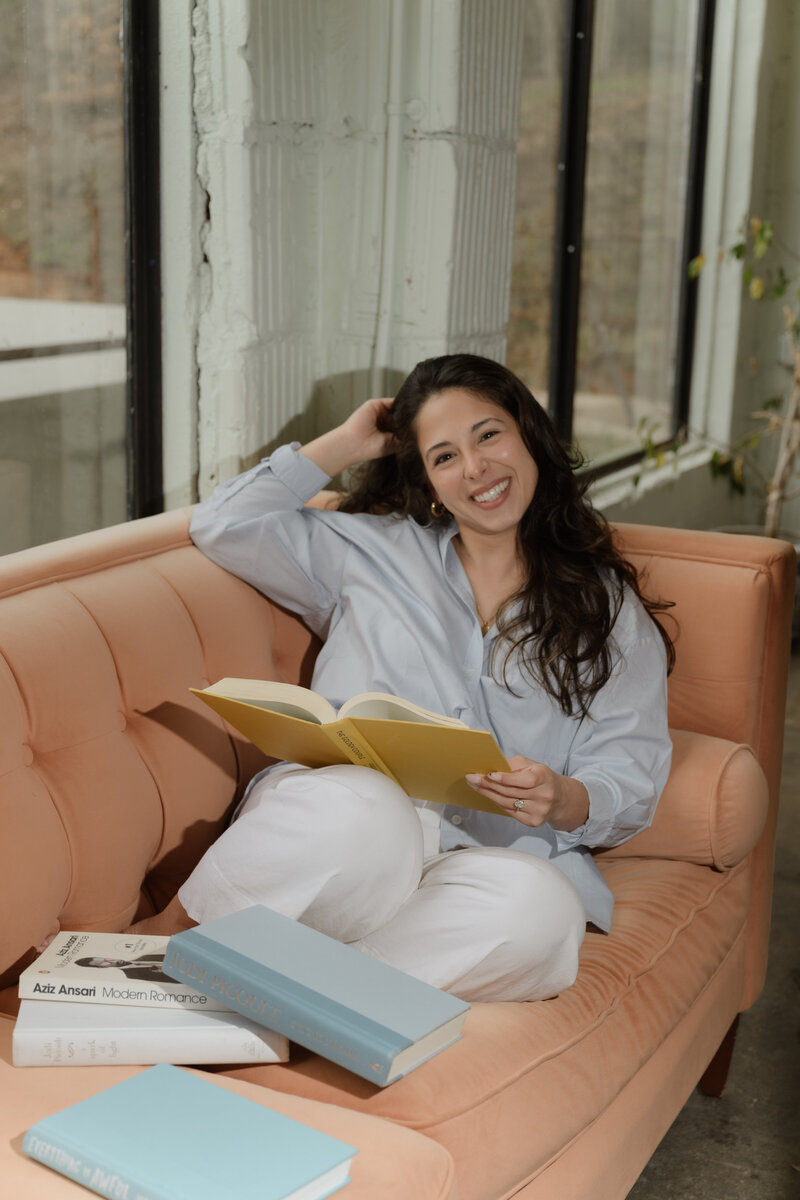 A website copywriter holding a book and smiling