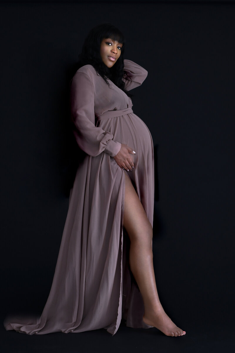 pregnant woman in black bodysuit holding belly