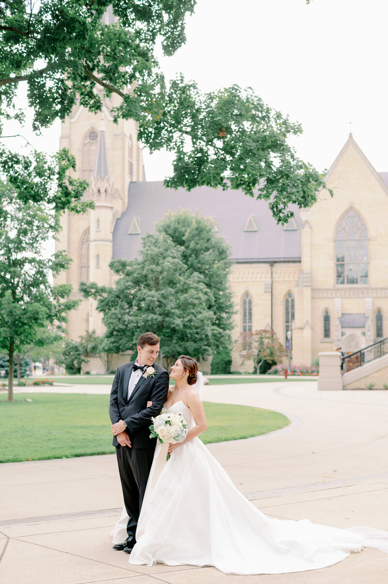 bride and groom walking on Notre Dame's campus