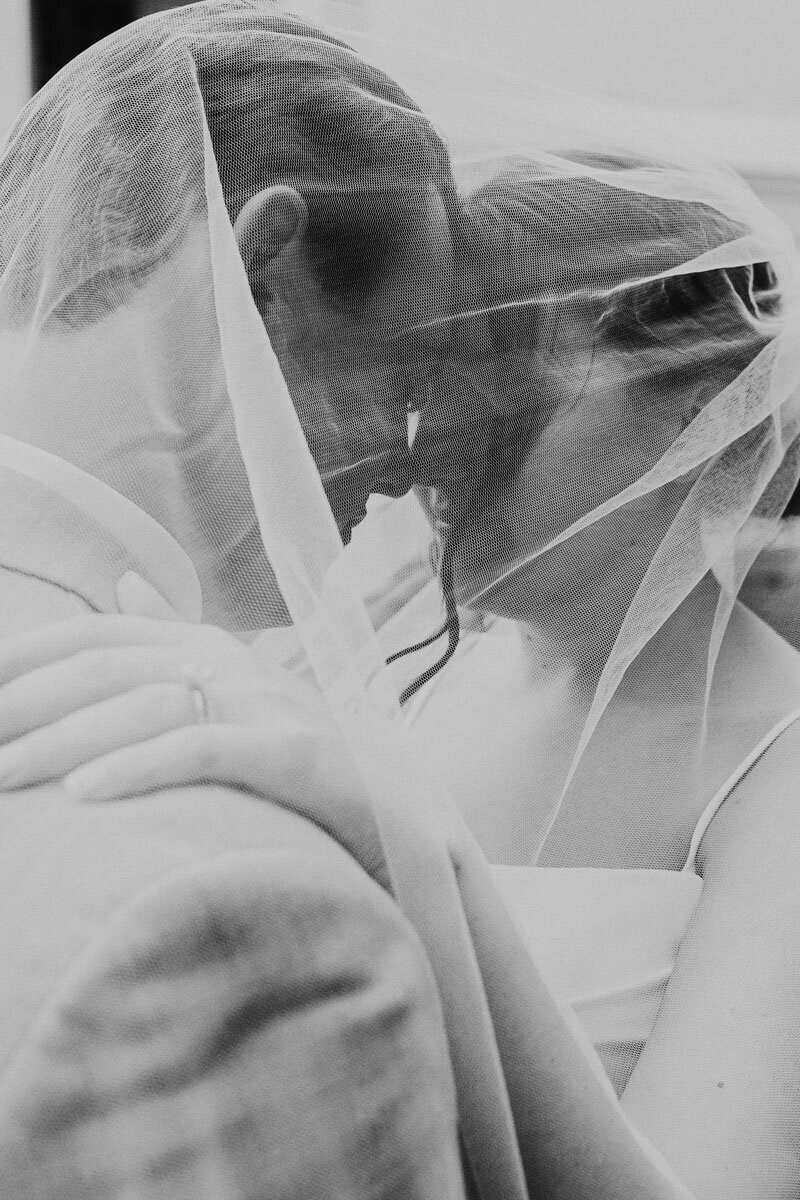Man and woman under woman's veil on wedding day