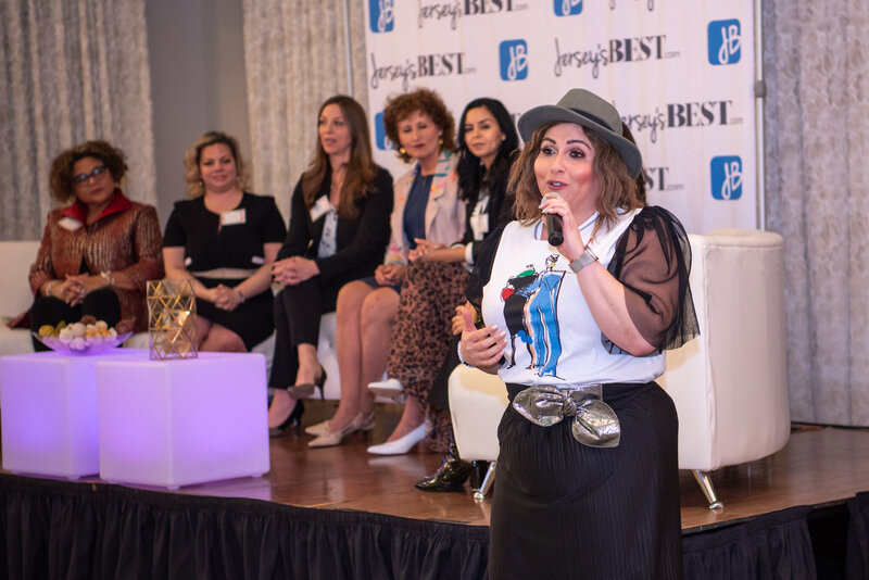 A female host talking to the audience at an International Women's Day Business Summit.