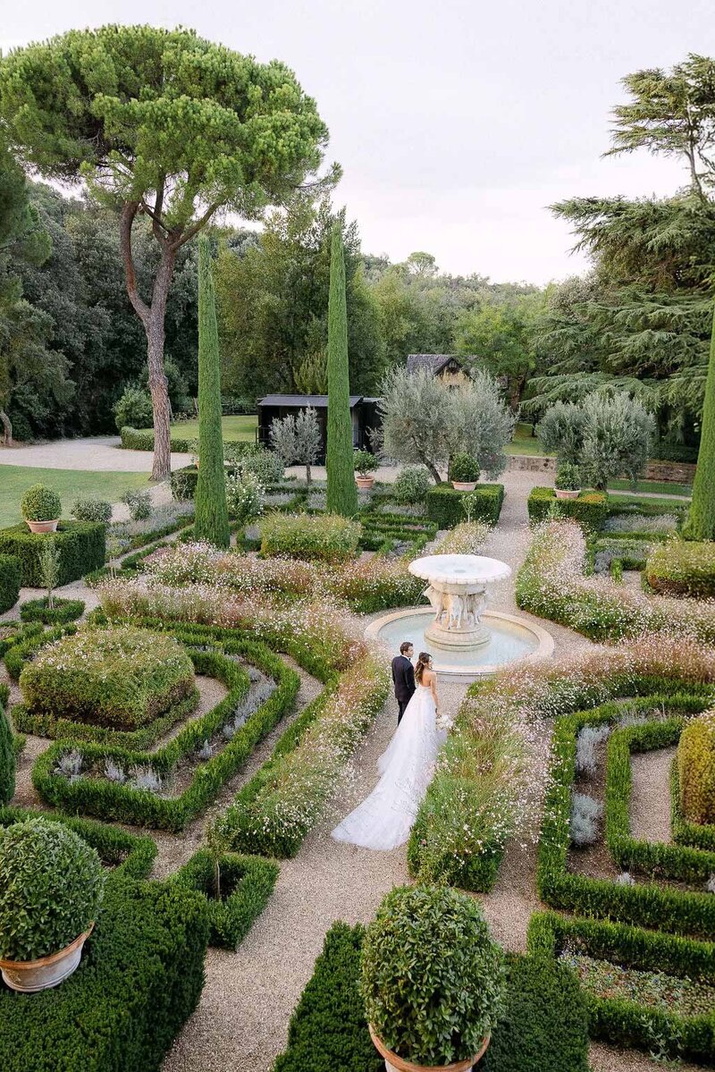 Drone image of couple walking at Tenuta Il Pallagio iconic garden in Tuscany.