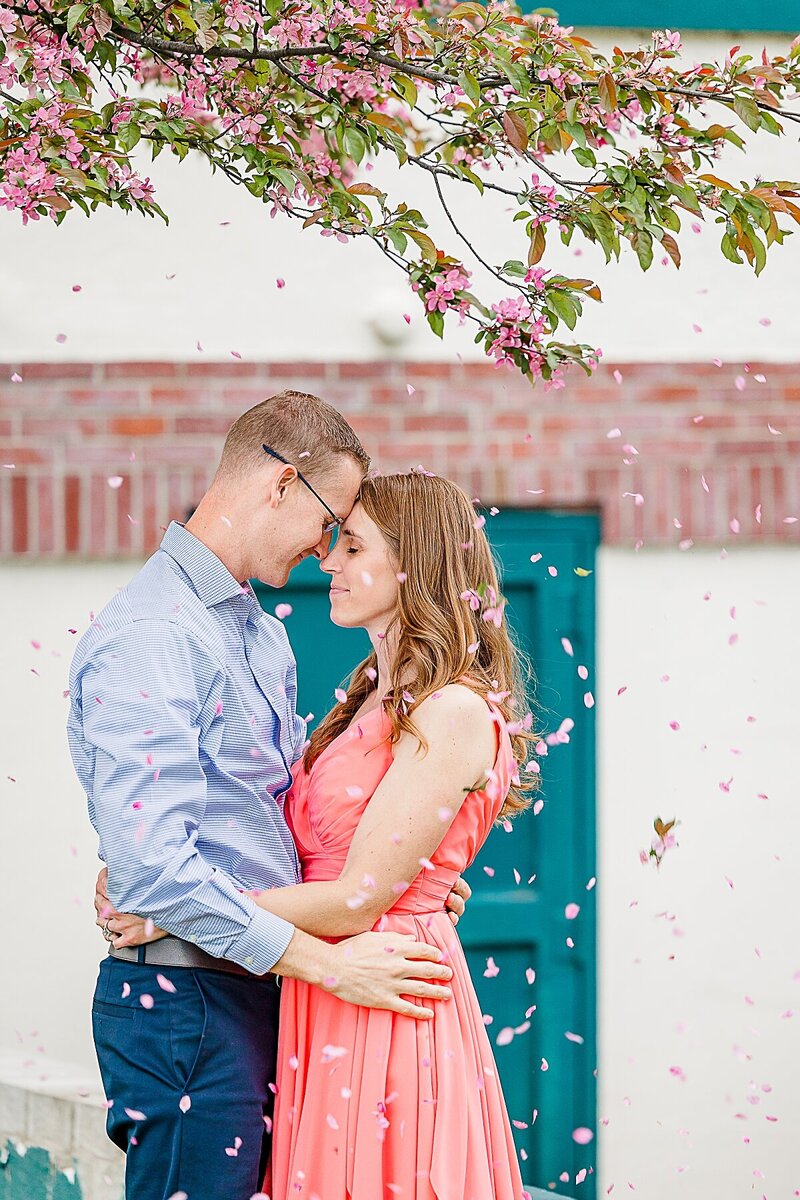 engaged-couple-hugging-under-cherry-blossom-tree