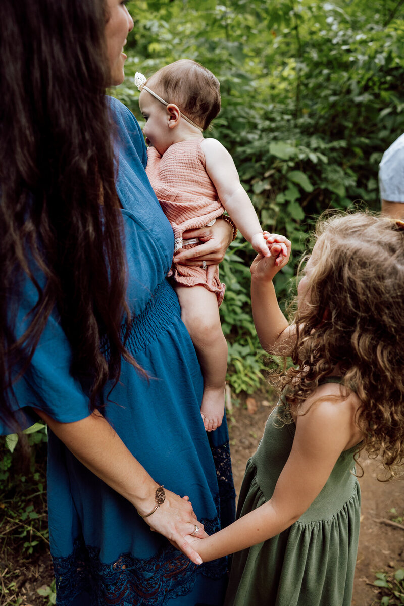 Candid portrait of daughers and mother taken in the woods in De Soto, Missouri. 