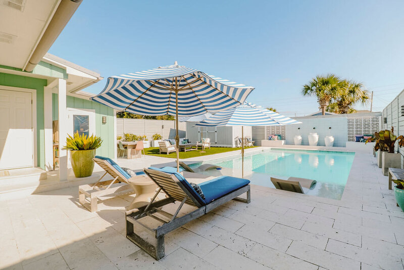 pool with blue loungers and striped umbrella