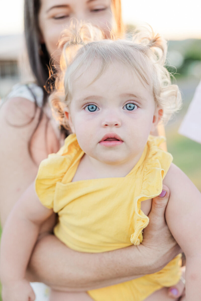 Sweet toddler portrait of a little girl wearing a daffodil yellow dress, taken by Yeppoon Family Photographer, Julie-Anne.