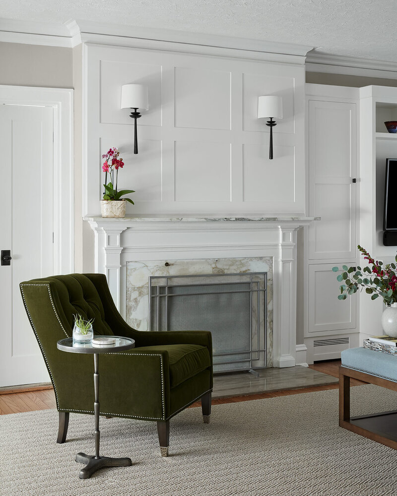 Olive green tufted chair with white fireplace