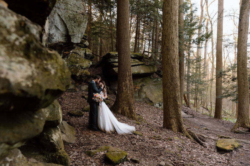 Couple embracing near rock formations at Ledges in CVNP.