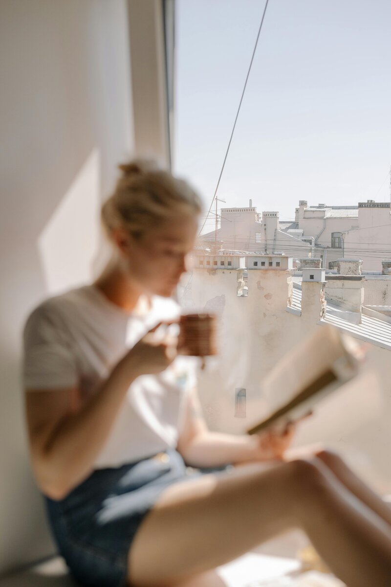 Woman sitting with coffee reading a book
