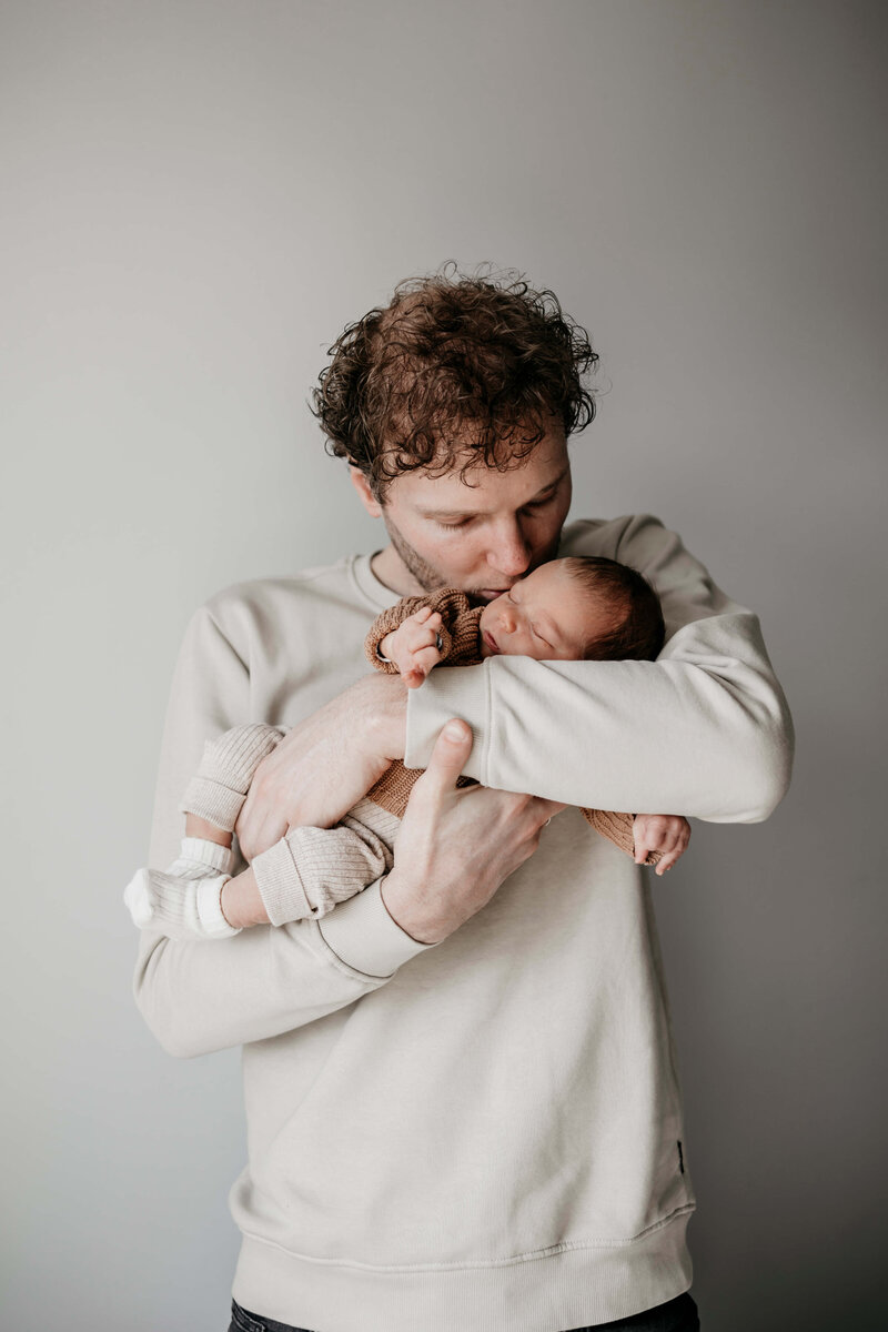 papa die zijn zoon kust en vasthoudt