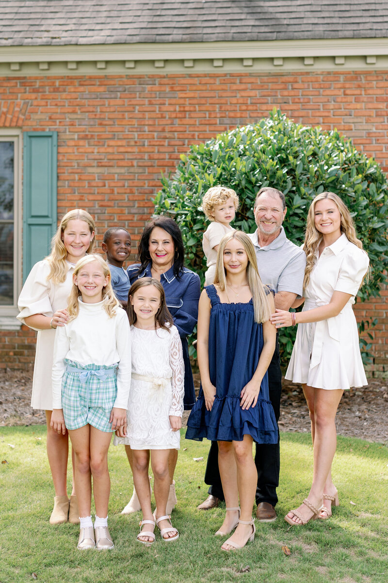 Family smiling in front of a home