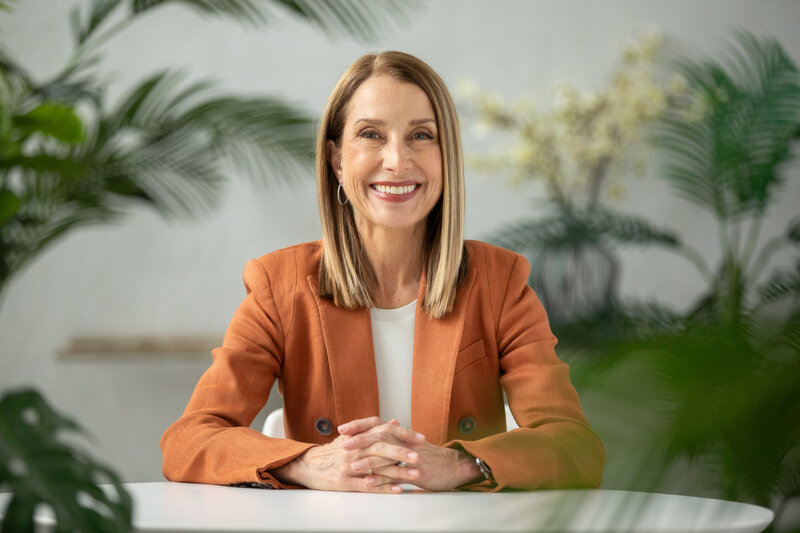 Nancy Himmelfarb smiling in a portrait, sitting comfortably
