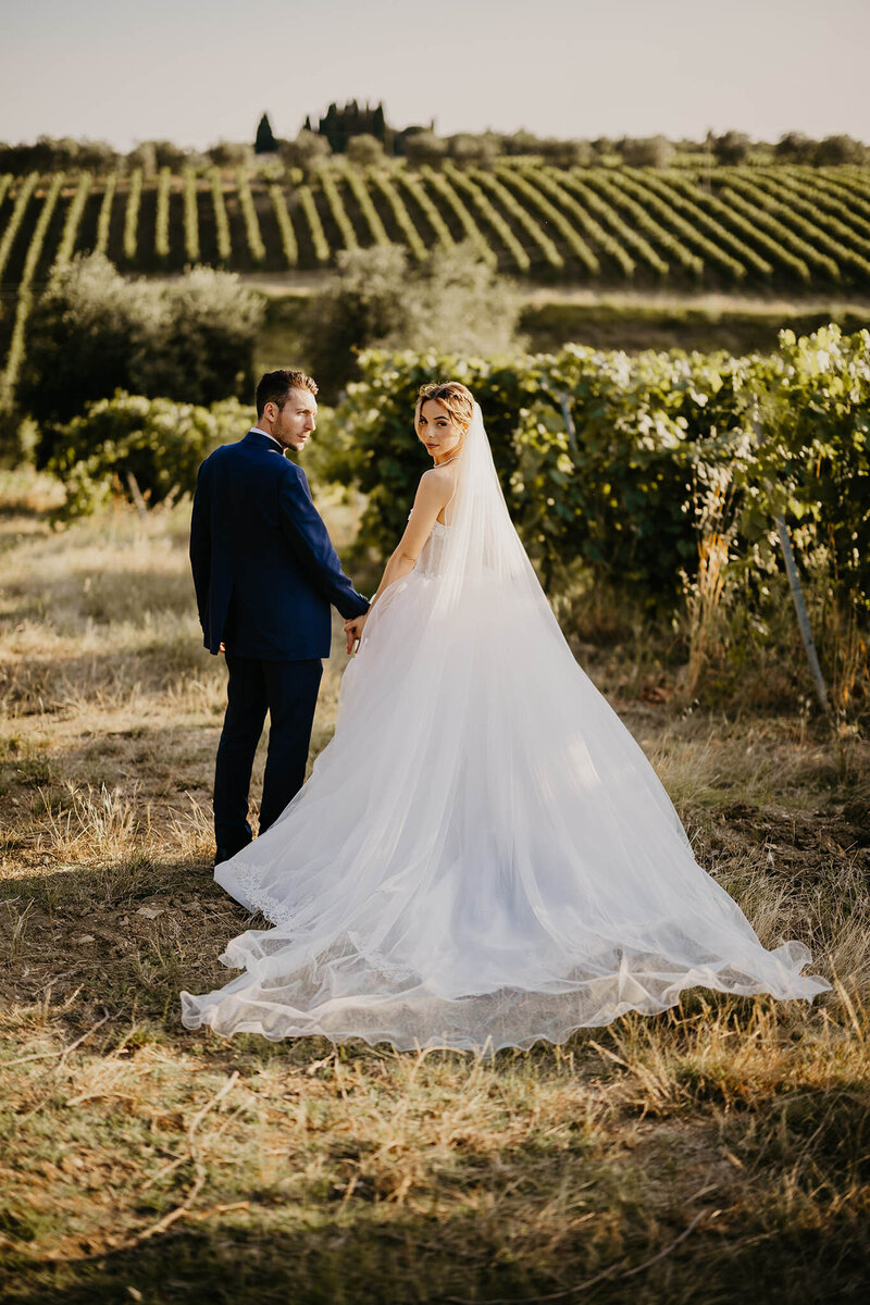 Coppia di sposi cammina tra le vigne del Casello il Palagio.