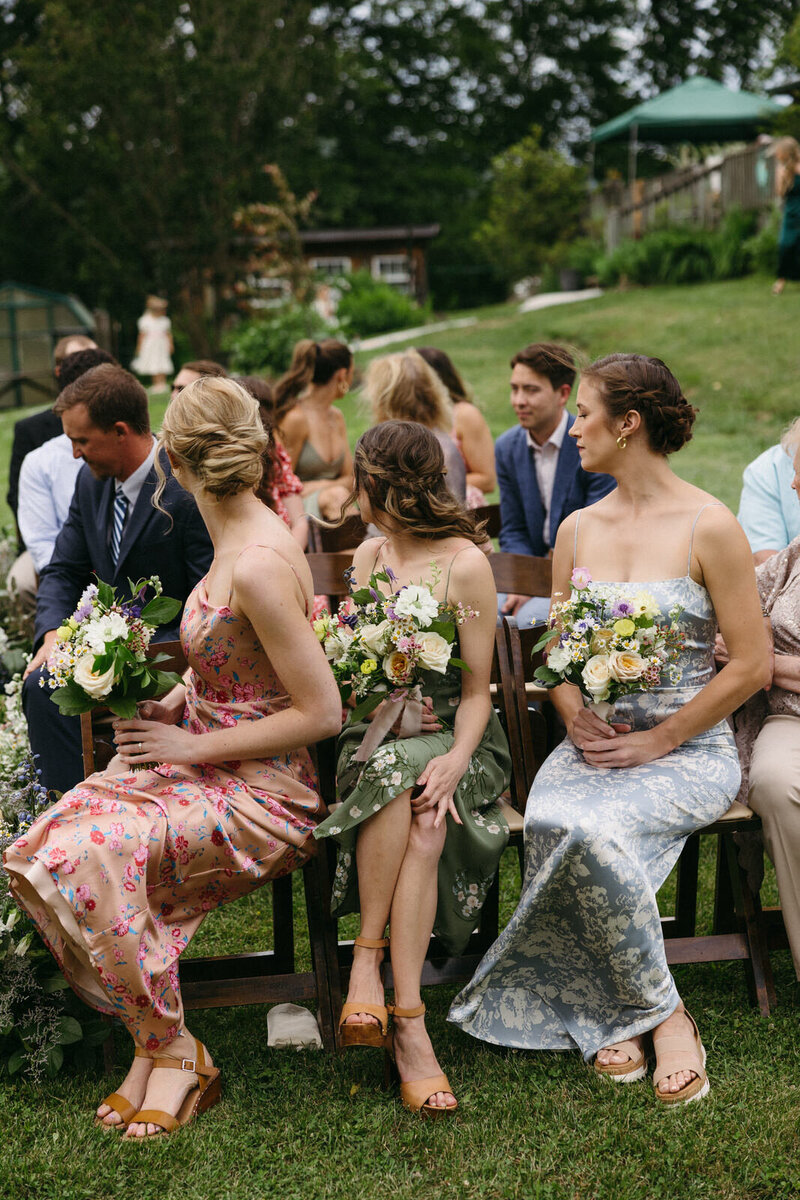 Bridesmaid's flroal dresses during a summer wedding ceremony in Asheville NC, documented by Andrea-Marie Photography
