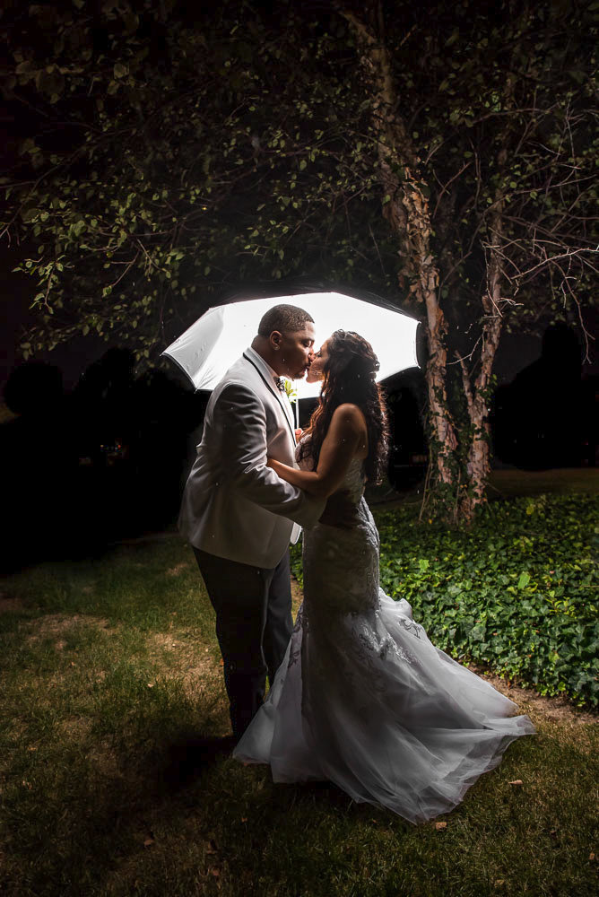 A kiss under an umbrella at nigh time