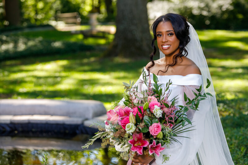 black bride  holding a lush pink and white bouquet