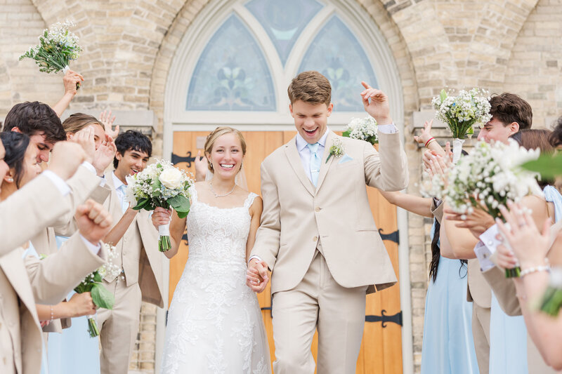 Wisconsin bride and groom celebrating as they leave a church after their wedding ceremony