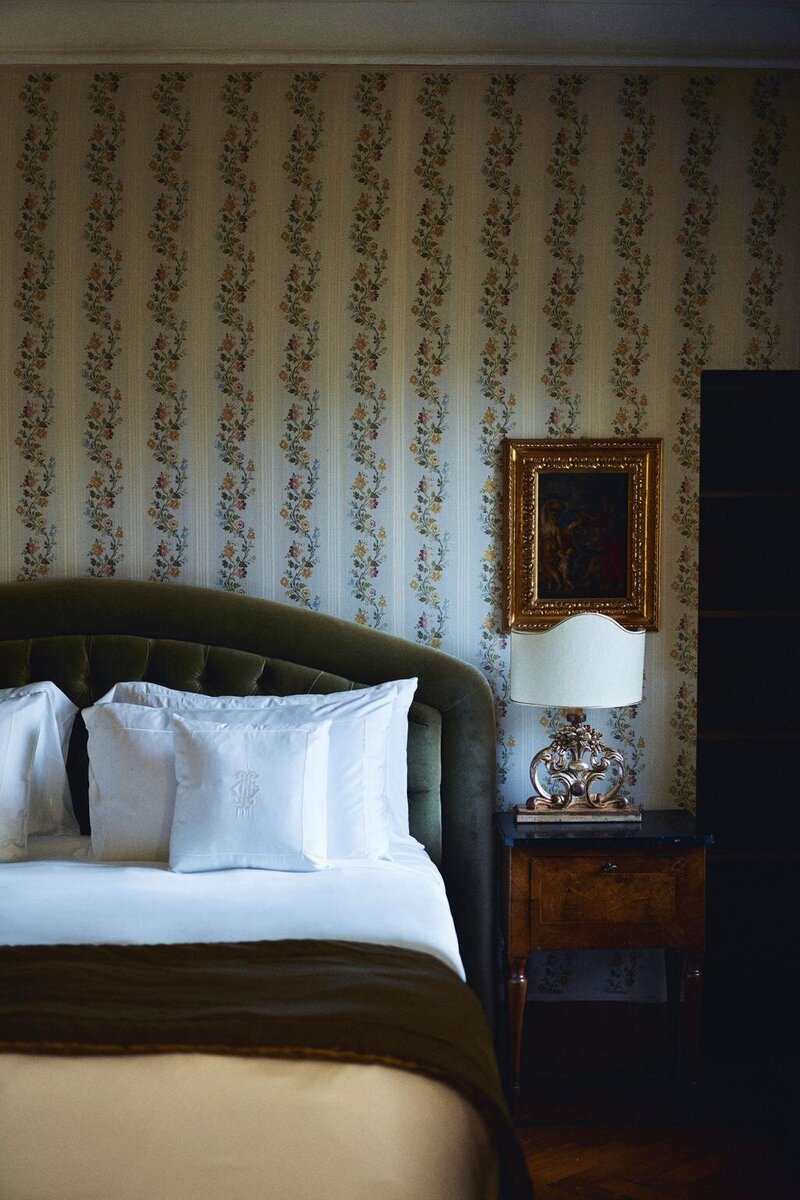 A refined and elegant writing desk at Borgo Santo Pietro with a large glass vase overflowing with white flowers and greenery